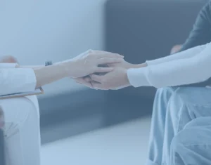 אישה מחזיקה את ידה של אישה אחרת.